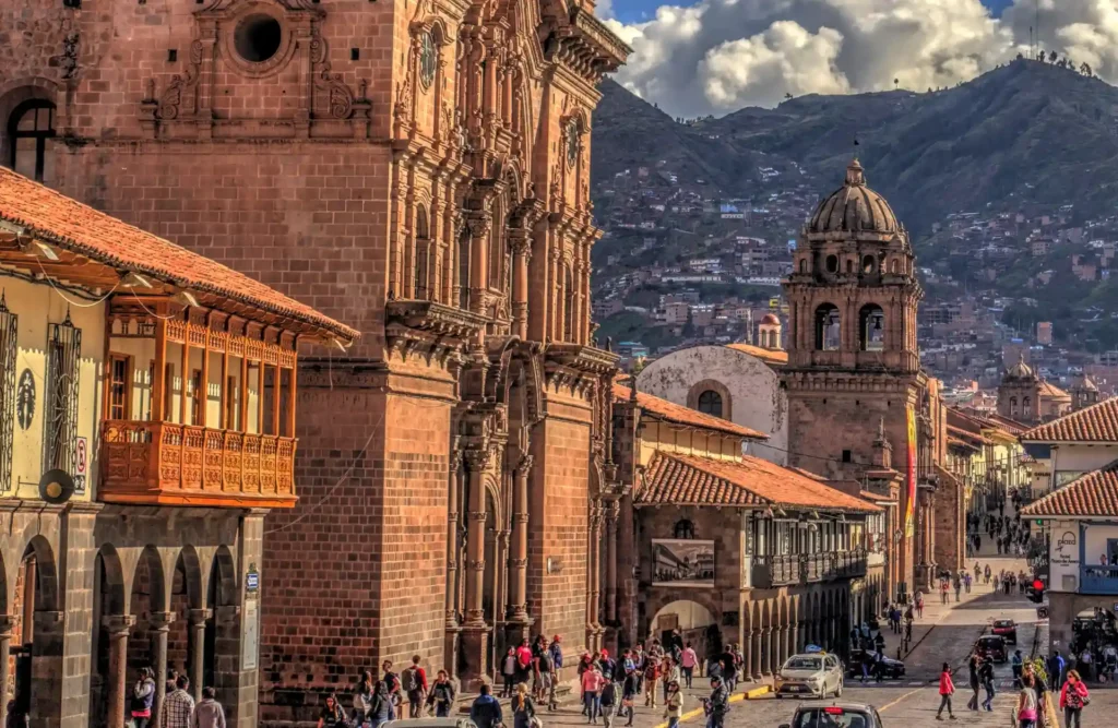 A non-stopping crowd walks in front of the Company of Jesus's church during the day.