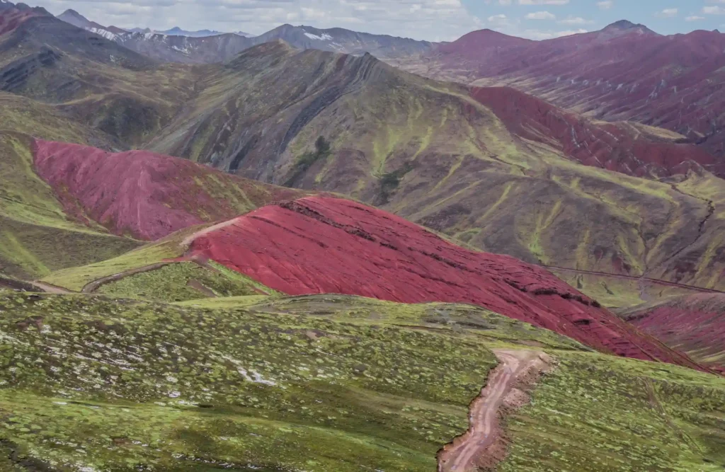 A view of the several red colored mountains that surround Palccoyo's summit